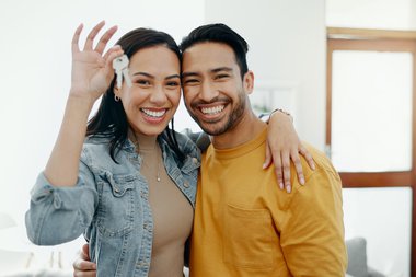 young-couple-holding-key-to-their-house